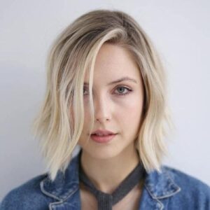 A choppy long bob on a blonde girl staring right in front of the camera