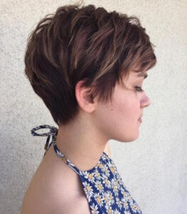 A soft pixie haircut in a girl with a blue floral tank top