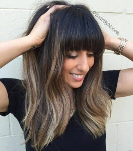 Cute girl holding her hair with full heavy bangs