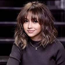 Smiling girl in a soft-layered lob with wispy bangs