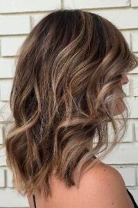 Wavy medium length hair with highlights haircut