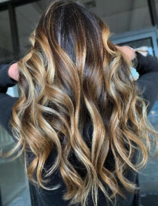 Flow and wavy hair in a metallic bronde balayage best for brunettes and Asian hair
