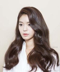 A doll-like beauty with wavy dark brown hair