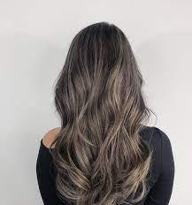 A subtle ash-brown hair color in wavy hair