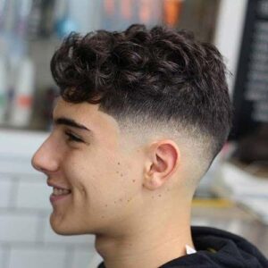 A smiling boy in a short curls hair