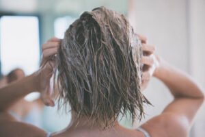 Lady exfoliating her scalp