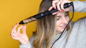 Girl using flat iron on her hair